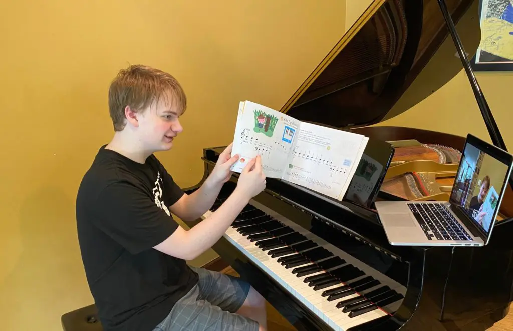 Teaching to Give's Hayden Miller tutors a fellow student in piano.