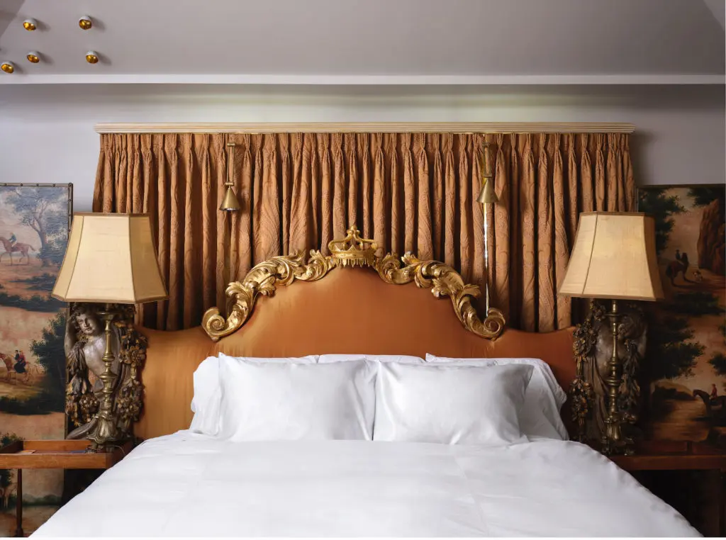 Headboard in this guest bedroom was designed by Alvise Orsini from antique Baroque architectural carvings. The upholstery and draperies are antique
bronze silks. (Photo by Lisa Petrole, Styled by Michelle Aviña)