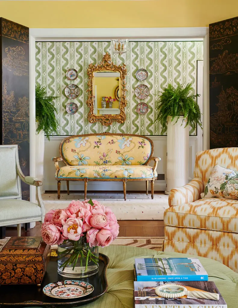 In a southern traditional interior, Mark Sikes placed ferns on pedestals; settee covered in Brunschwig & Fils fabric. Quadrille wallpaper. (Photo Amy Neunsinger)