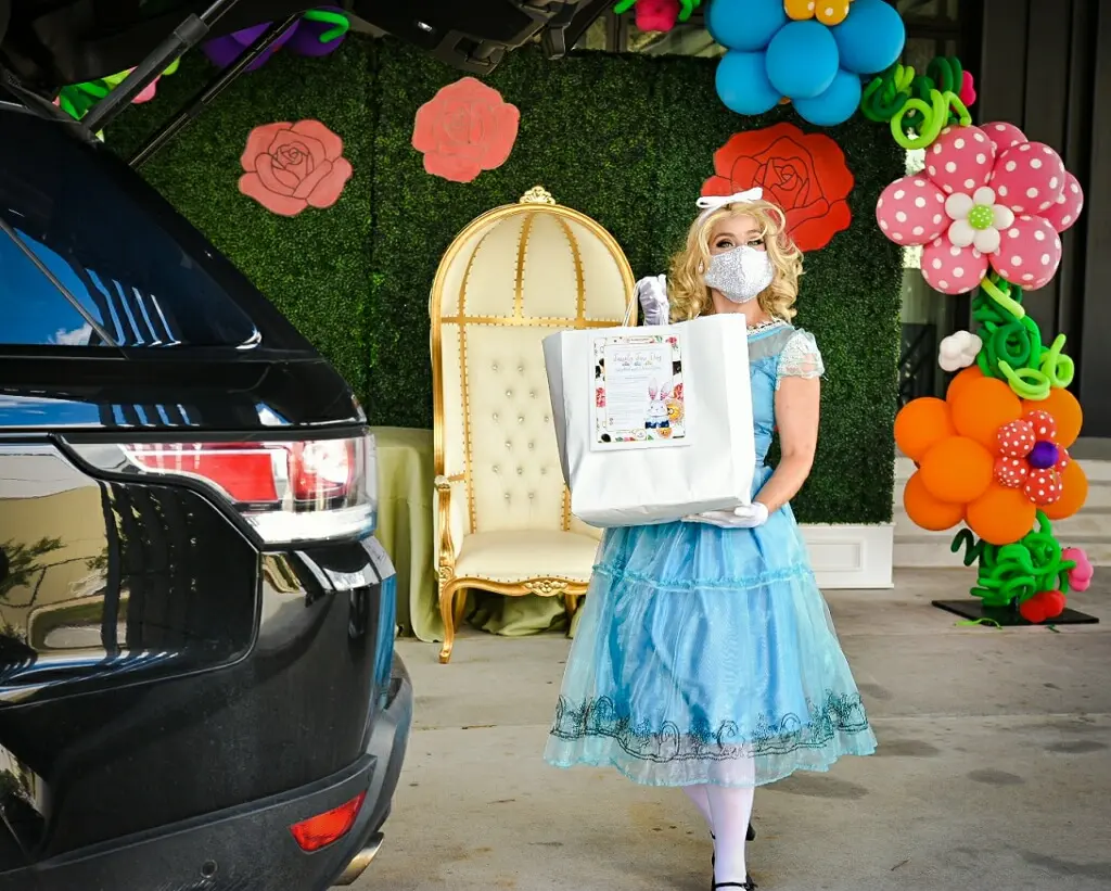 Alice hands out dinner from A Fare Extraordinaire as participants drive through this most unusual wonderland. (Photo by  Brandy Stoesz Photography)