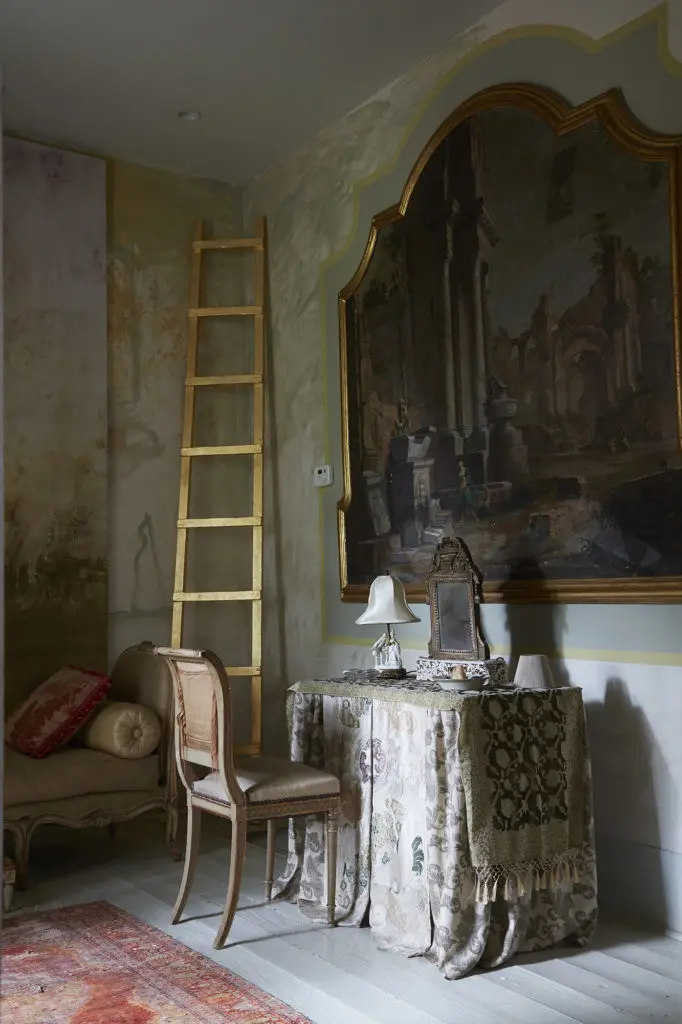 In the cottage called Here & There, Gold-leaf "Jacob's Ladder" by Werner-Vaughn. The 17th-century painting belonged to Napolean's sister. The vanity is draped in antique Fortuny velvet. (Photo by Lisa Petrole, Art Direction by Michelle Aviña)