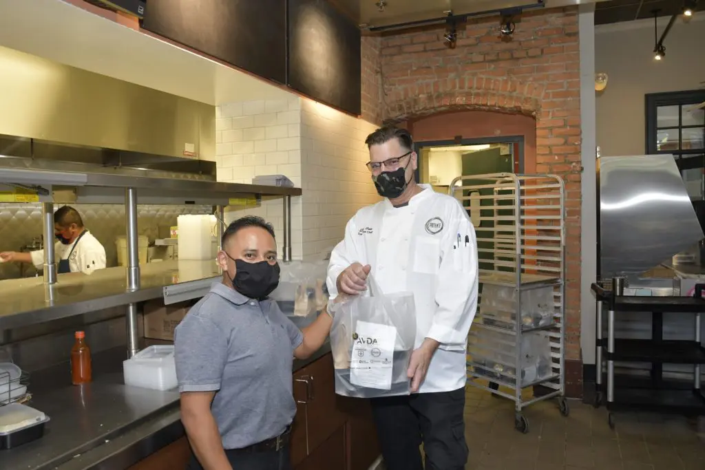 Potente Chef Danny Trace hands off a four-course dinner package from the kitchen at Minute Maid Park. (Photo by Jerry Klumpp)