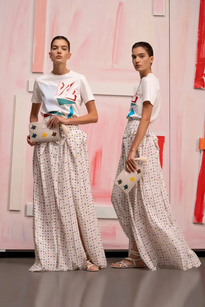 Akris ecru cotton jersey T-shirt with cutout application, Kinderstern print silk crêpe long skirt with
volume waist pleats, Alexa tassel pouch in canvas with Multicolor Kinderstern patchwork. (Photo courtesy of Akris)
