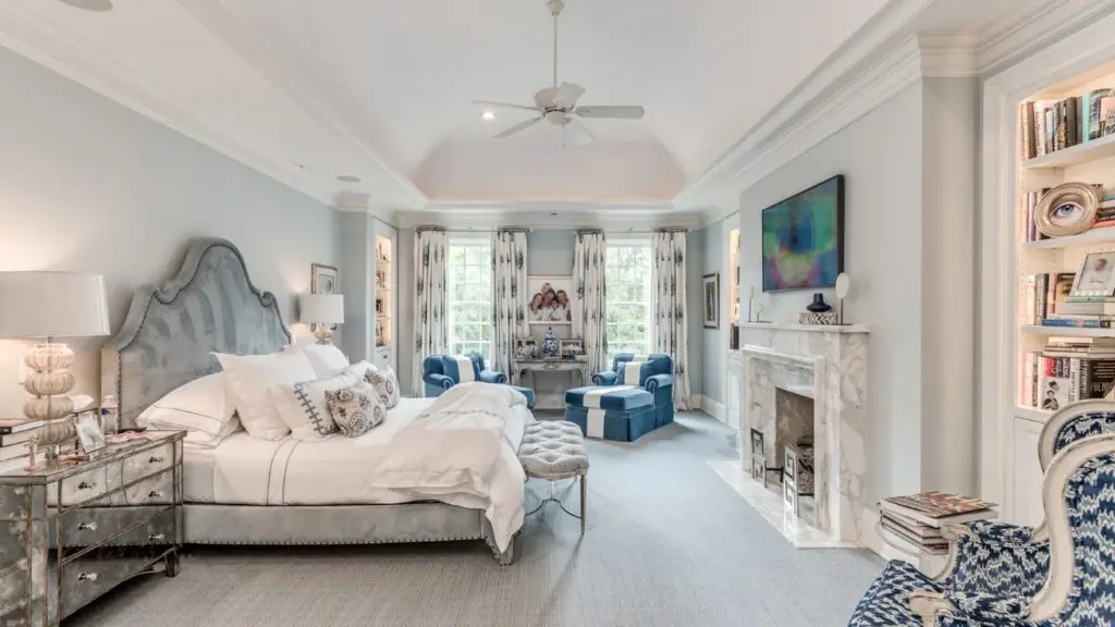 Master bedroom in a dusty gray blue with white marble mantle.
