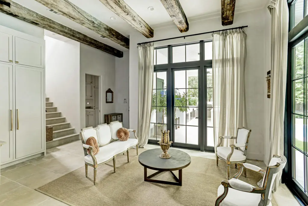 The sun room features dual exposures from floor-to-ceiling French doors with transom windows.
