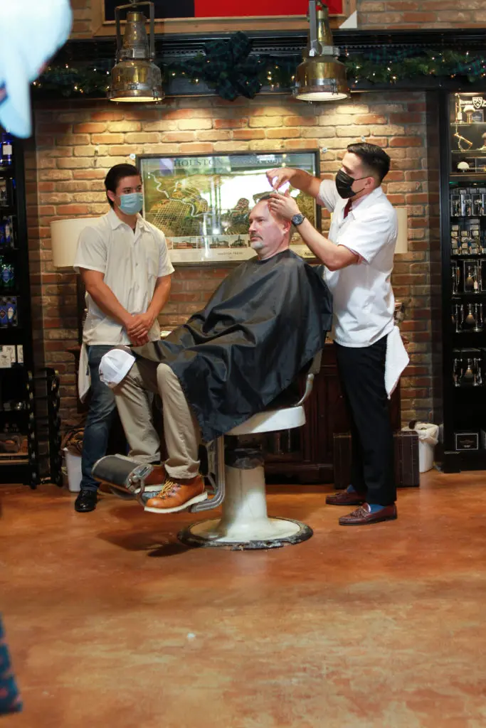 Augie Bering steps into the Bering's barber chair for a haircut and a shave during the store's 80th anniversary celebration. (Photo by Chris P. Bachman )