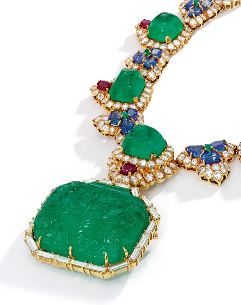 </b>Emerald, Ruby, Sapphire and Diamond Necklace, David Webb</b>
Suspending a rectangular-shaped carved emerald pendant, framed by baguette diamonds, the necklace set with numerous square-shaped sugarloaf cabochon emeralds, accented by oval-shaped rubies, spaced by oval-shaped sapphires, further decorated with round diamonds, length 15 inches, necklace signed David Webb; circa 1970s. With signed box.
Estimate $75/100,000
