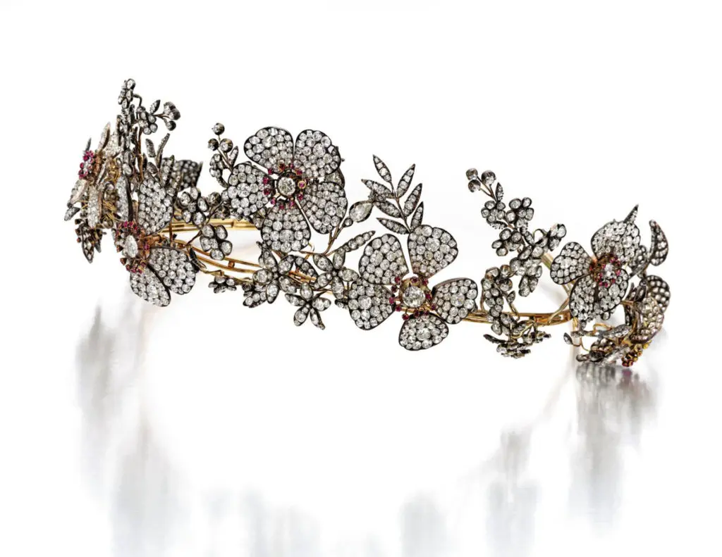 <b>Silver-Topped Gold, Ruby and Diamond Tiara</b>
Of garland design, featuring floral and foliate motifs pavé-set with old mine, old European, pear, single and rose-cut diamonds, accented with cushion-cut and round rubies, one diamond missing; mid-19th century. With fitted case
Estimate $100/200,000
