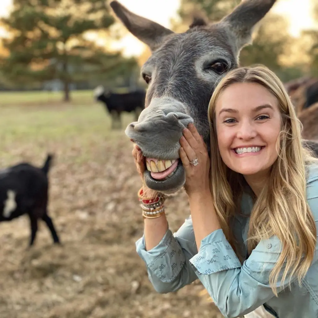 Frances Moody embraces a rescue donkey that she and fiancé Tony Buzbee retrieved from Habitat for Horses. Buzbee's ranch in East Texas is home to numerous rescued animals. (Photo by Vivian Arcidiacono)