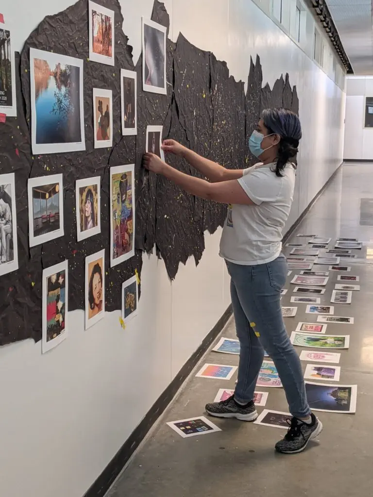 Co-curator, Crystal Correa, carefully completes installing the challenging exhibition.
