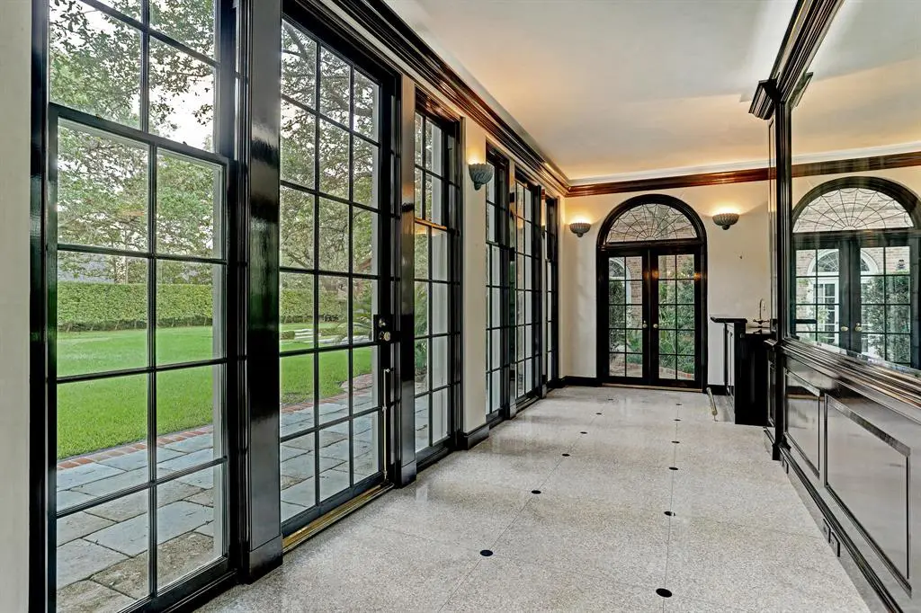 Fanciful Chinese-Chippendale wooden gates at 3229 Groveland announce the sun-lit rear gallery floored in terrazzo inlaid with black granite rondels. 