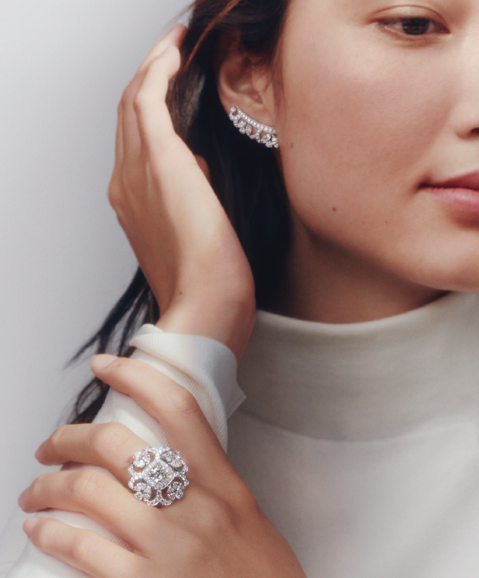 Marquise and round brilliant accent diamonds embrace the 2.18 carat cushion cut diamond ring in the Ellesmere Treasure set in De Beers' high jewelry Reflections on Nature collection. The white diamond climber earrings are part of the collection. (Photo courtesy of De Beers Jewellers)