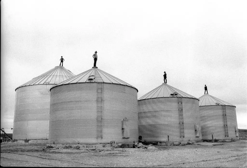 Laura Wilson's "Teenage Boys Standing Like Sentinels on Top of Grain Silos, Duncan Ranch Colony (Lehrerleut)," 1991 at Red & White Gallery.
