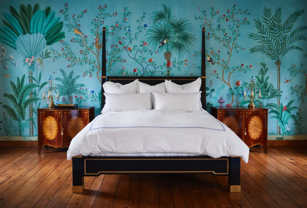 Bed with gilt details by Grazzini Furniture. De Gournay Amazonia wallpaper. Dallas artist David Lyles hand-painted switch plates to match the wallpaper. (Photo by Pär Bengtsson)