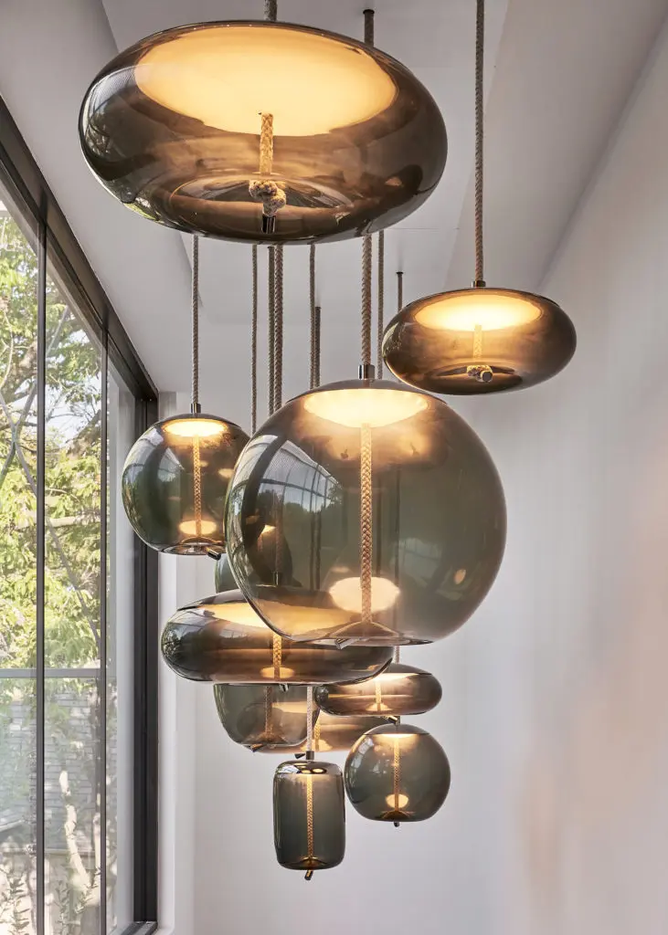 In the stairwell, smoked-glass pendants by Brokis are suspended by natural fibers. (Photo by Stephen Karlisch)