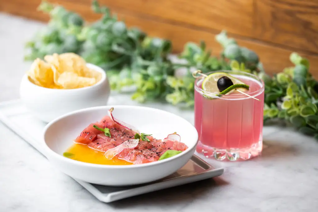 Tuna crudo is a popular starter at Saint Ann along with the Flamingo cocktail. (Photo by Kathy Tran)