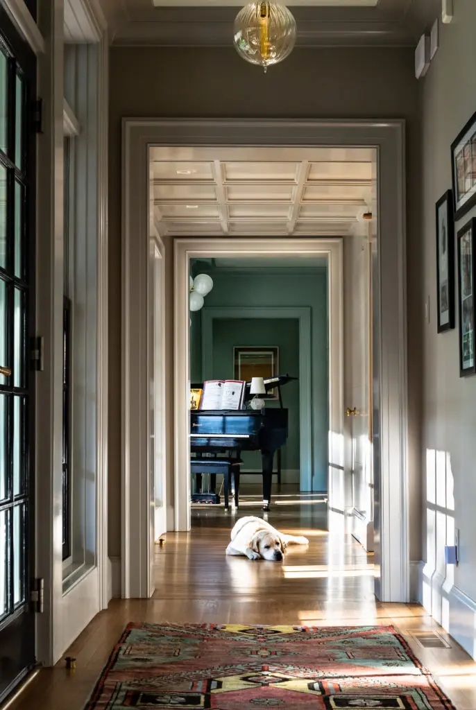 Family golden retriever Floyd suns himself in rays of light in the hallway. Many of the ceilings in the house are wood coffered. (Photo by Manny Rodriguez)