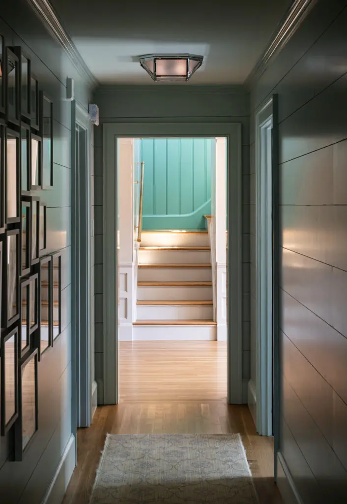 Even back hallways and stair landings are beautiful, with shiplap walls painted in various blues. In the living room, herringbone white oak floors and hand-built windows give the house a crafted, traditional feel. (Photo by Manny Rodriguez)
