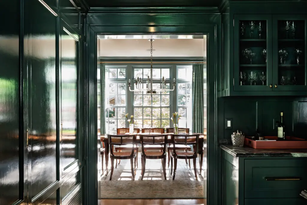 In the butler’s pantry, custom cabinetry
by V Fine Homes is hand-brushed in Farrow & Ball paint. Classic Brass in
New York handmade all the hardware
for the house. The 1940s dining-room
table and chairs belonged to Lizzie Sell’s
grandmother. Visual Comfort chandelier. (Photo by Manny Rodriguez)