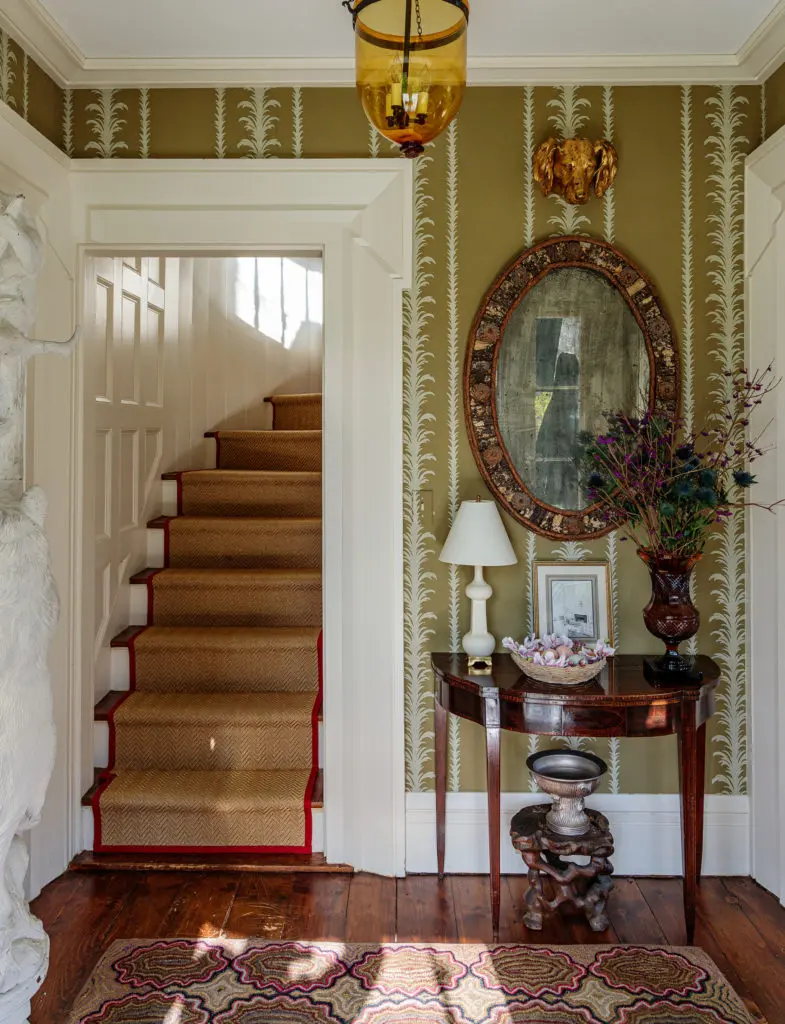 In the entry of Clove Brook Farm, a gilt tole dog’s head
that once belonged to Mario Buatta and a watercolor by
Mark Hampton of Albert Hadley’s barn in Maine. Cole &
Sons wallpaper.