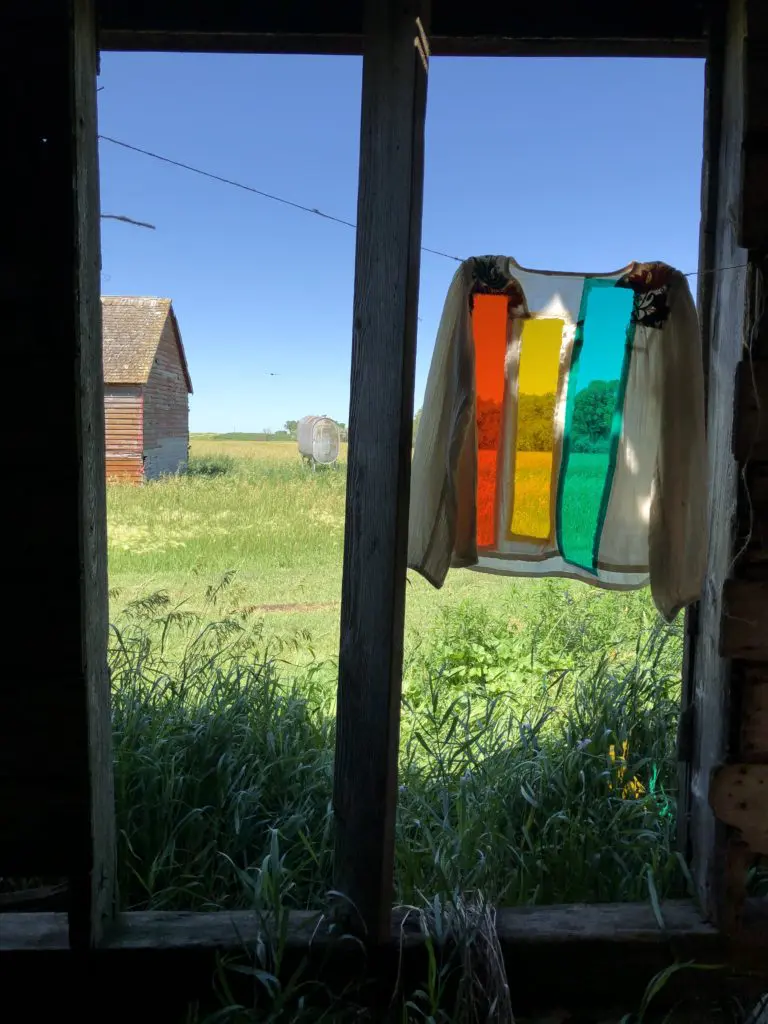 A garment-inspired handmade textile dialogues with a weathered South Dakota barn, summer 2020.