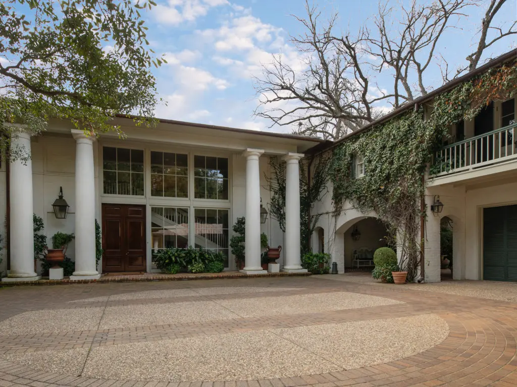 At 7000 Vassar Avenue, the eclectic, Neoclassical home flanked by towering oak trees was designed by architect Gayden Thompson and builder C.B. Christensen for the Volk Family.
