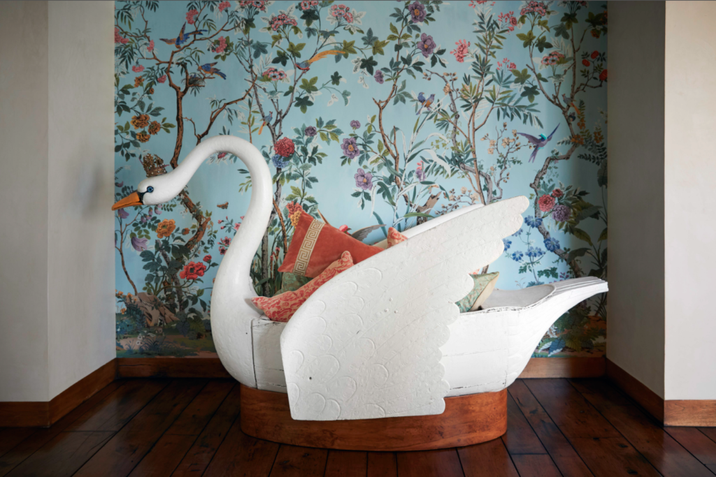 The 18th-century swan rowboat, displayed like a piece of sculpture and filled with Fortuny pillows, once belonged to the children of a noble French family and was kept on their pond in southern France. Zuber hand-painted wallpaper. (Photo by Pär Bengtsson)