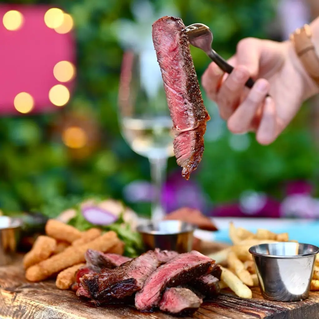 Amanda's Board comes with rib eye steak, pork loin, jalapeno sausage, Yuca fries, French fries, and green salad. (Courtesy of Ocho)