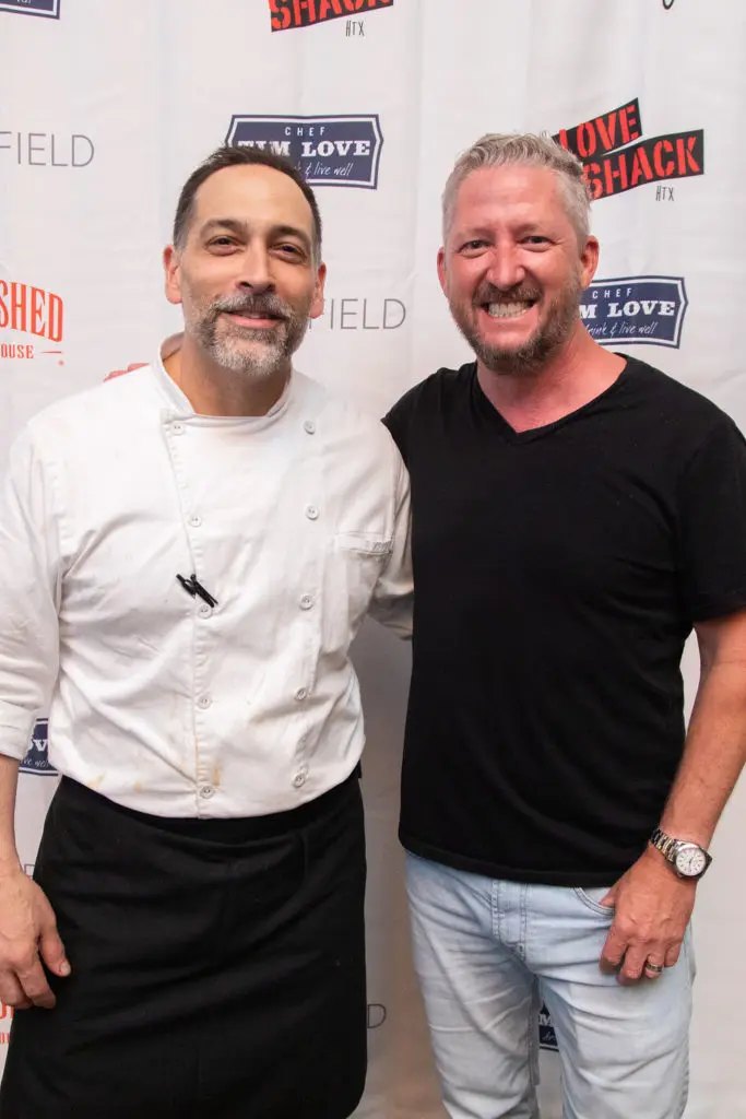 Woodshed Smokehouse chef de cuisine Brian Mottola and owner/chef Tim Love of Fort Worth celebrate the reopening of the Houston locale in Levy Park. (Photo by Leah Wilson)