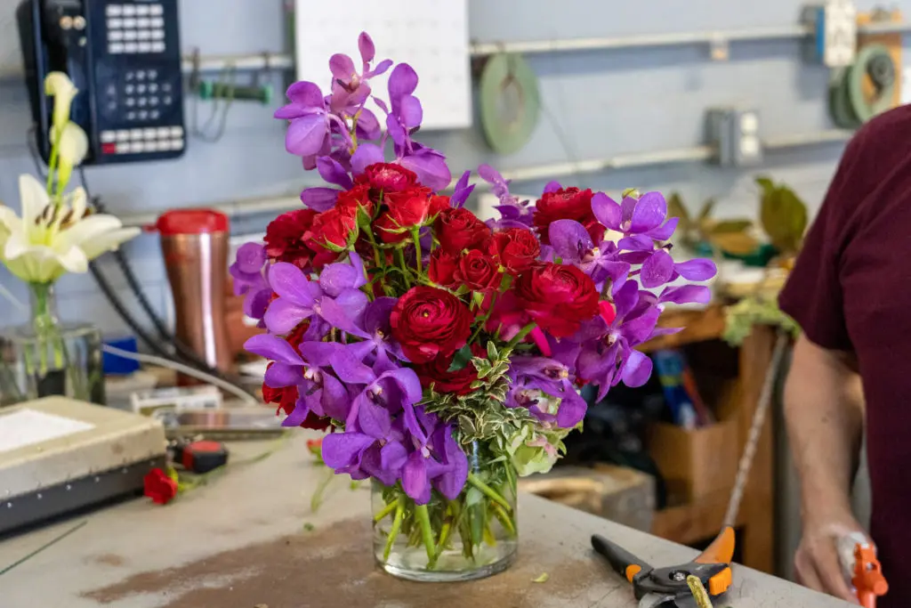 The bold palette for this In Bloom Inc. arrangement is created from vivid orchids and bold ranunculus and roses. (In Bloom Inc. photo)