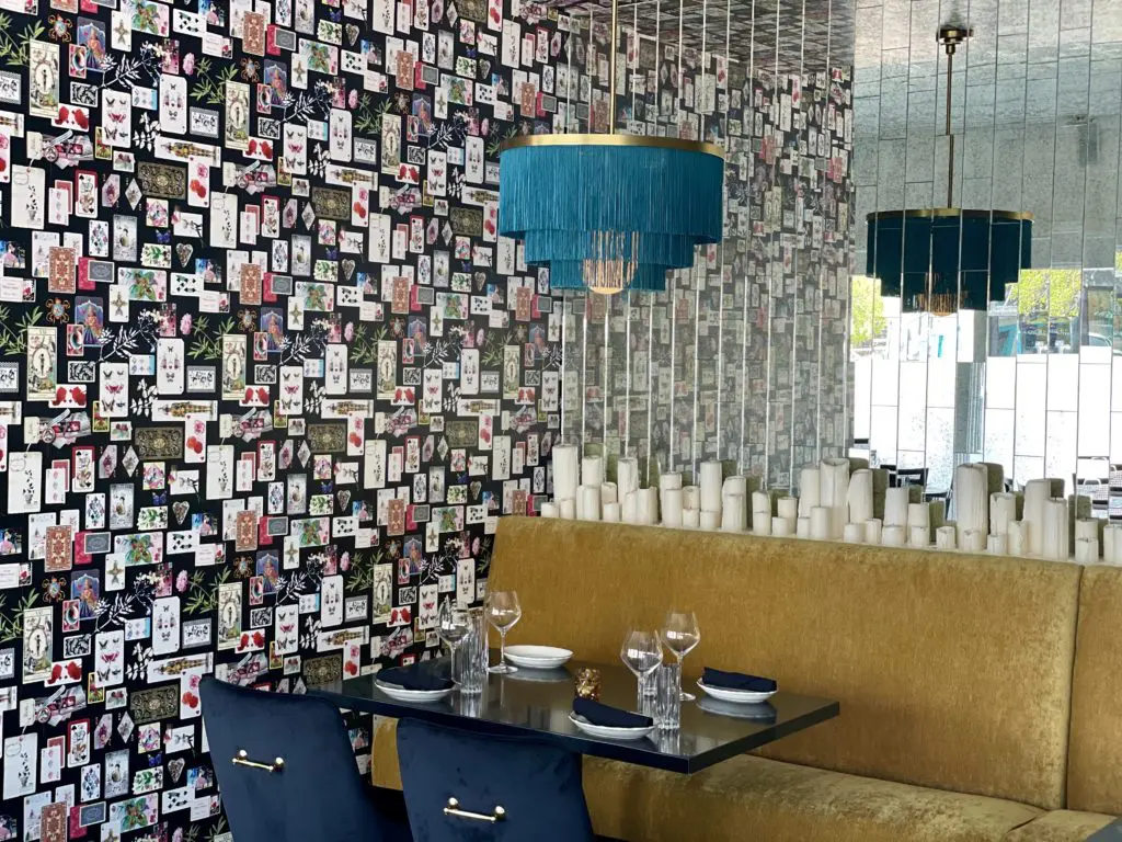 Âme's decor includes velvet gold couches and Christian LaCroix's Maison de Jeu wallpaper. (Photo by Kathy Tran)