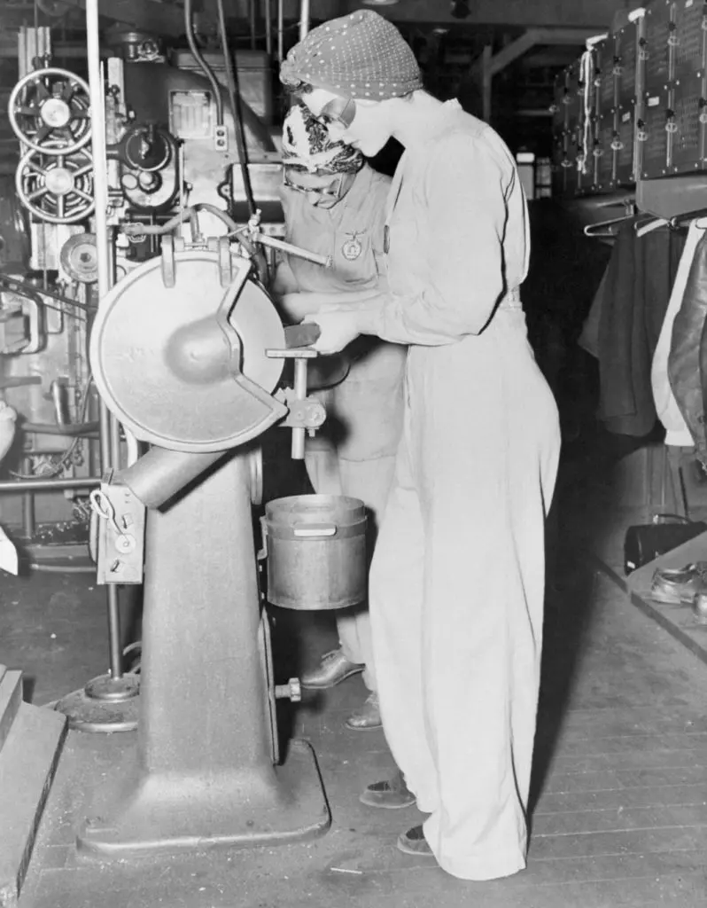 Though not dressed for a dance, Naomi Parker aka Rosie the Riveter, foreground, and Frances Johnson look alright to us. Their clothes are the proper ones for women workers at the Alameda Naval Air station. For safety and efficiency the girls are ordered to wear slack suits, heavy shoes, no jewelry, and turbans during work hours. (Photo by Bettman/Getty Images)