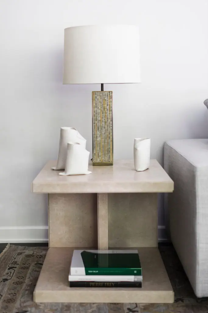 Living-room side table in honed limestone by Wendy Konradi. Embossed-parchment-and-bronze lamp by Mary Kuzma, from Emily Summers Studio. Porcelain ceramics by Fanny Laugier, from BK Antiques, NY. (Photo by Addison Jones)