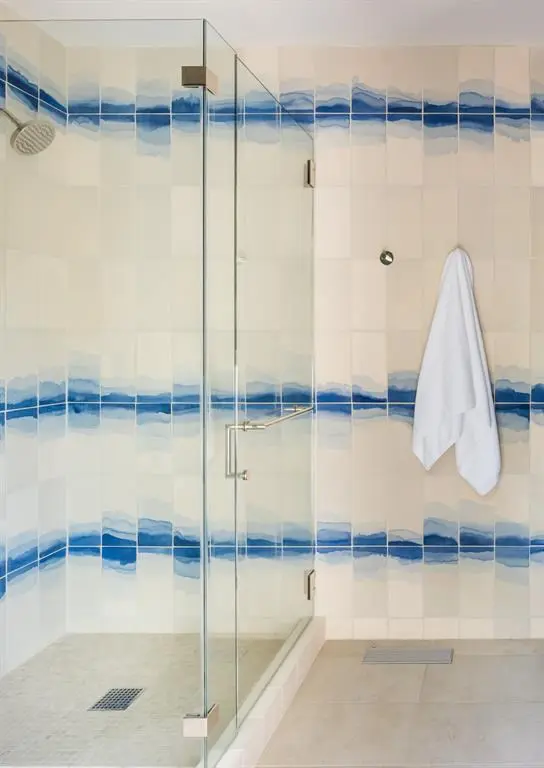 Watercolor tiles add a memorable touch to a walk-in shower. 