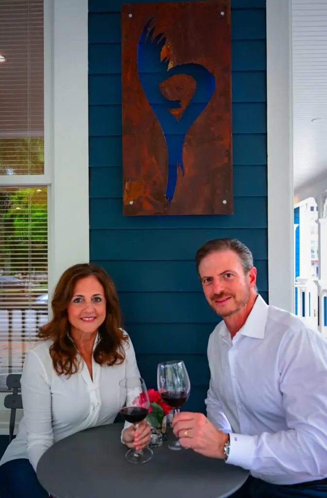 Carolina & Sergio Weitzman on the porch of their Serca Wines tasting room and event space in The Heights.