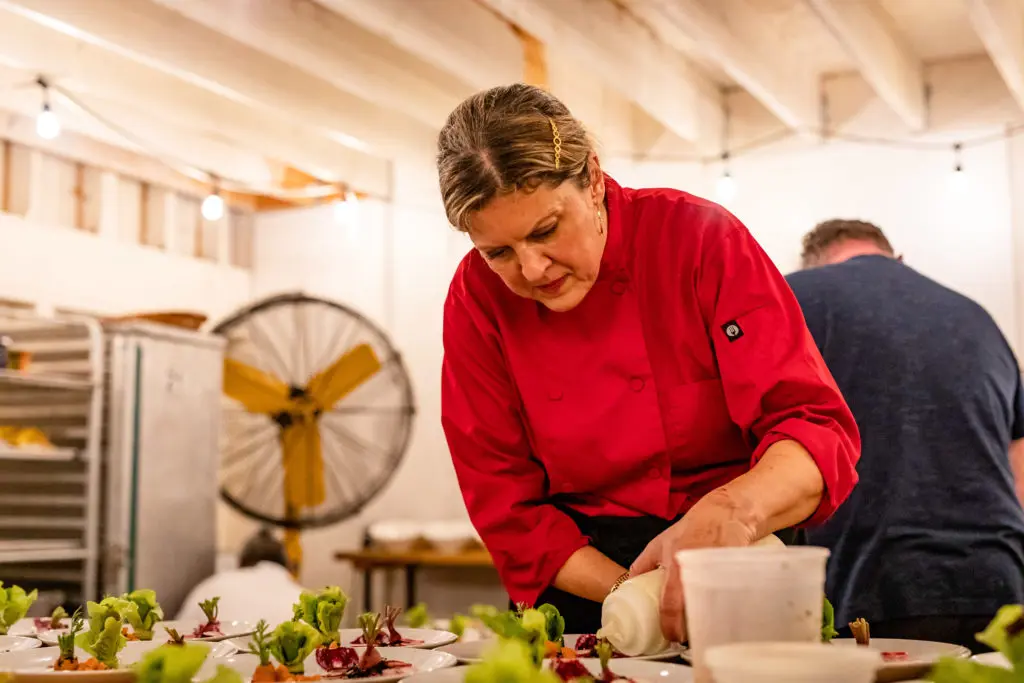 Chef Barbara McKnight of Culinaire prepares the salad course for the Recipe for Success Delicious Alchemy dinner. (Photo by Kirsten Gilliam)