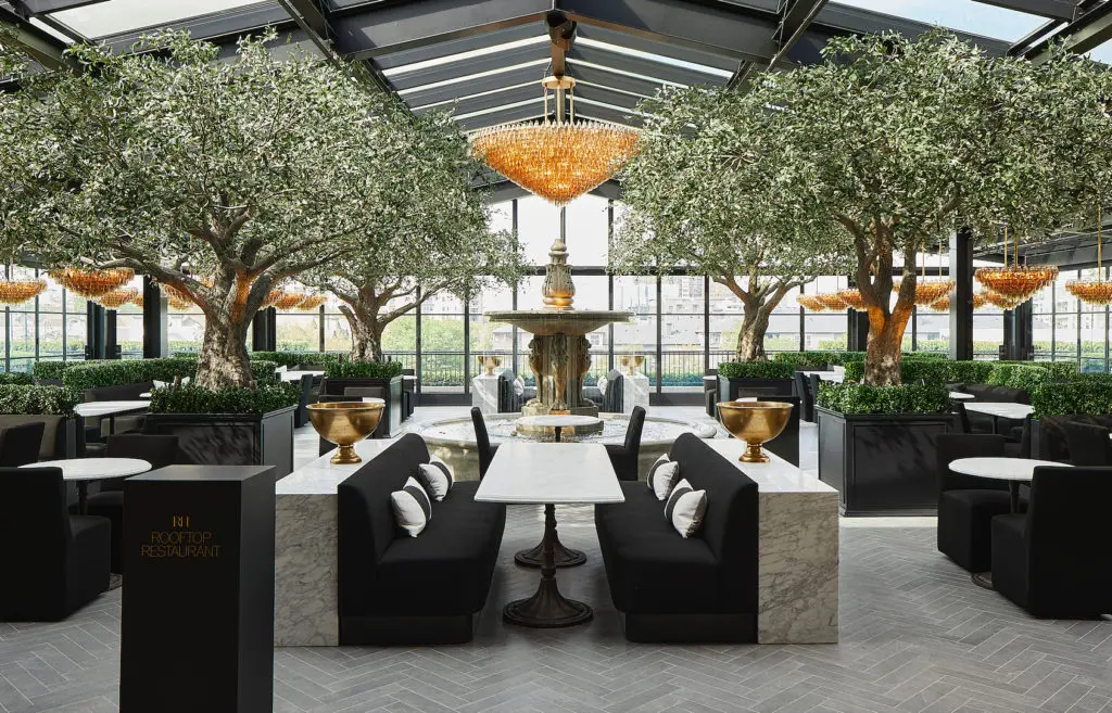 Inspired by classical European gardens, the Rooftop Restaurant and Park seamlessly brings the outdoors in with towering heritage olive trees, statement chandeliers, and an atrium with retractable glass walls (Photo by R2ro Photography)