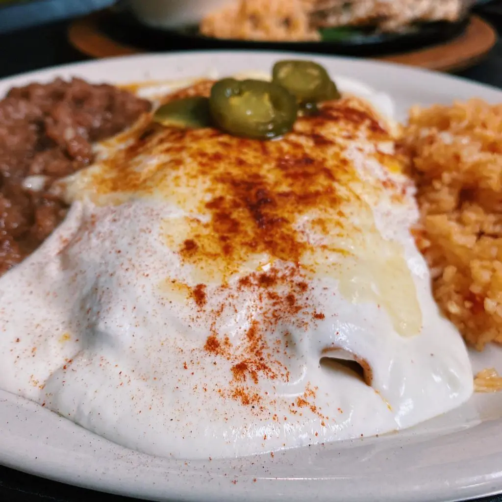 A silky sour cream sauce drapes the chicken enchilada plate - still some of the best in town.
