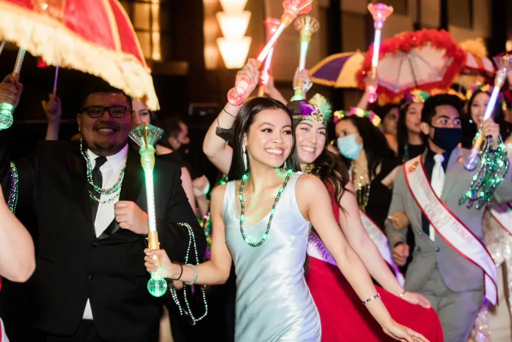 University of St. Thomas students and Natasha Nguyenphat join the second line parade during the university's 2021 Mardi Gras Ball.
