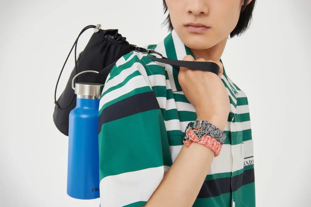 Prada shirt, $1,240; Prada bracelet (black), $295; Prada bracelet (orange), $295; Prada bottle, $105; Prada hammock, $875