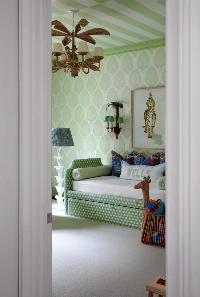 In the nursery, Katie Ridder wallpaper, Madre daybed and artwork, Mario Lopez Torres wicker light pendant. Vintage sconces. (Photo by Pär Bengtsson)