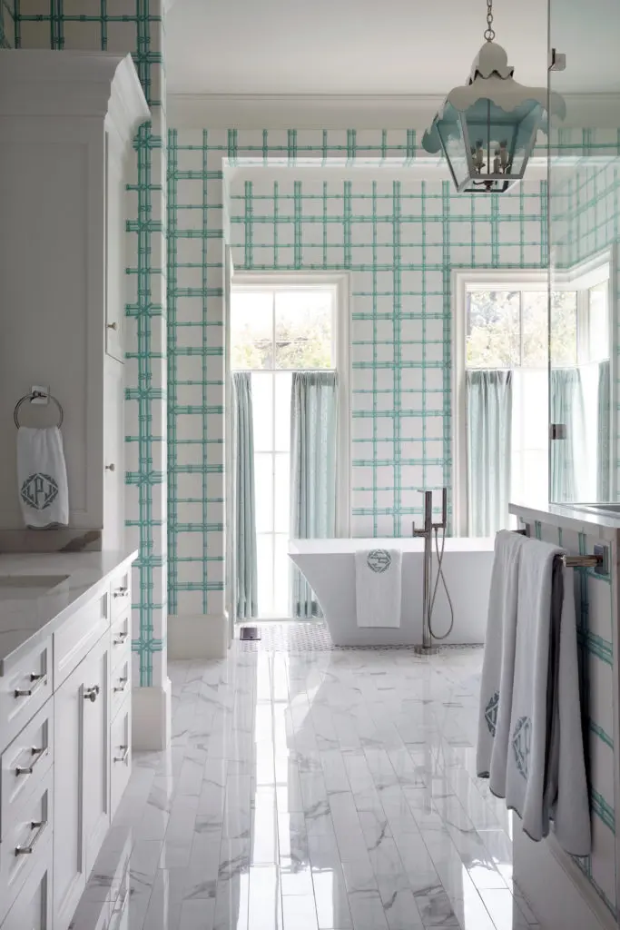In the main bath, Meg Braff wallpaper is custom-colored to coordinate with Kravet bamboo fabric draperies. Coleen & Company lantern. Leontine Linens bath accessories. (Photo by Pär Bengtsson)