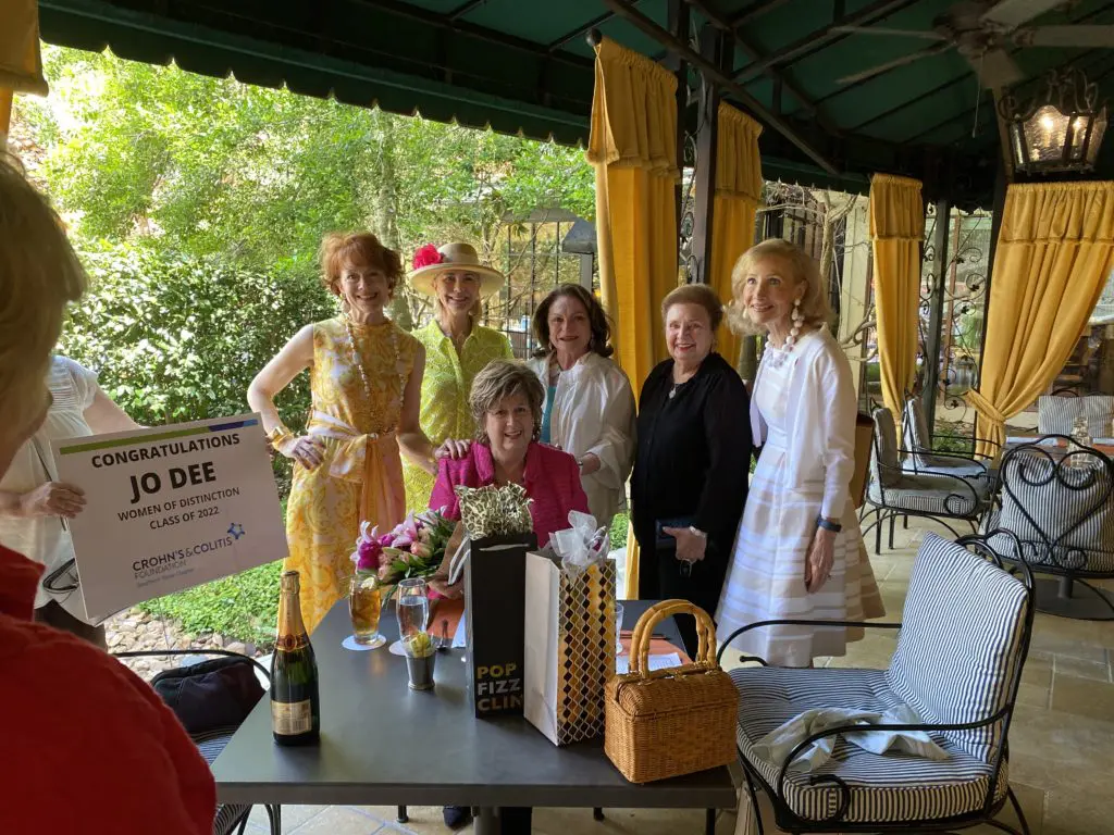 Jo Dee Wright, seated, is surprised with  announcement at the Hotel Granduca that she has been named a 2022 Women of Distinction honoree. 