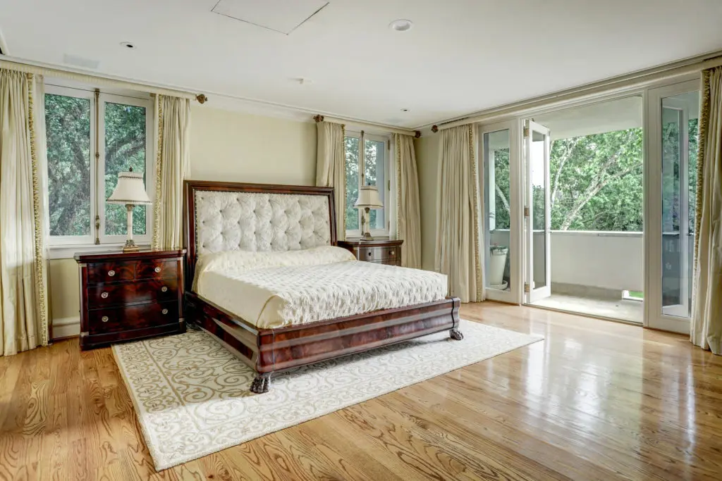 Behind the mirrored sitting room is the impeccable primary bedroom which features an abundance of natural light from a wall of French doors which lead to one of two covered balconies. (Photo by TK Images)