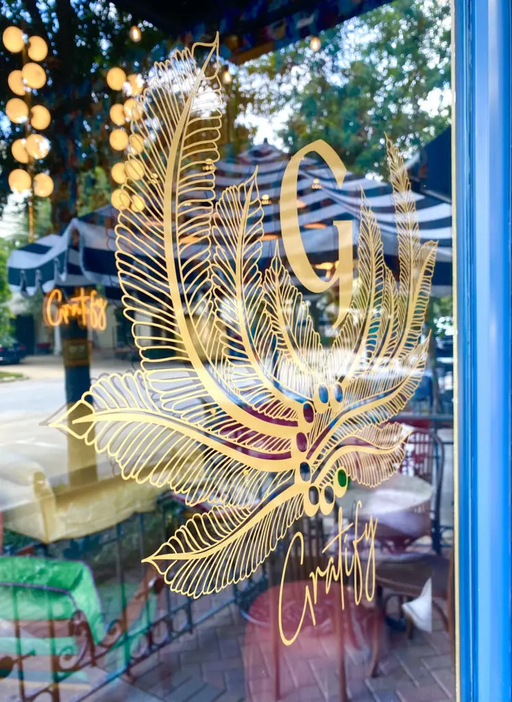The gilded Gratify crest on the restaurant's front door indicates the swank interiors of the West University restaurant.