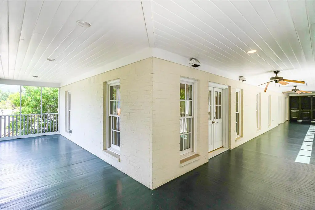 A screened-in porch runs the length of the second story. 