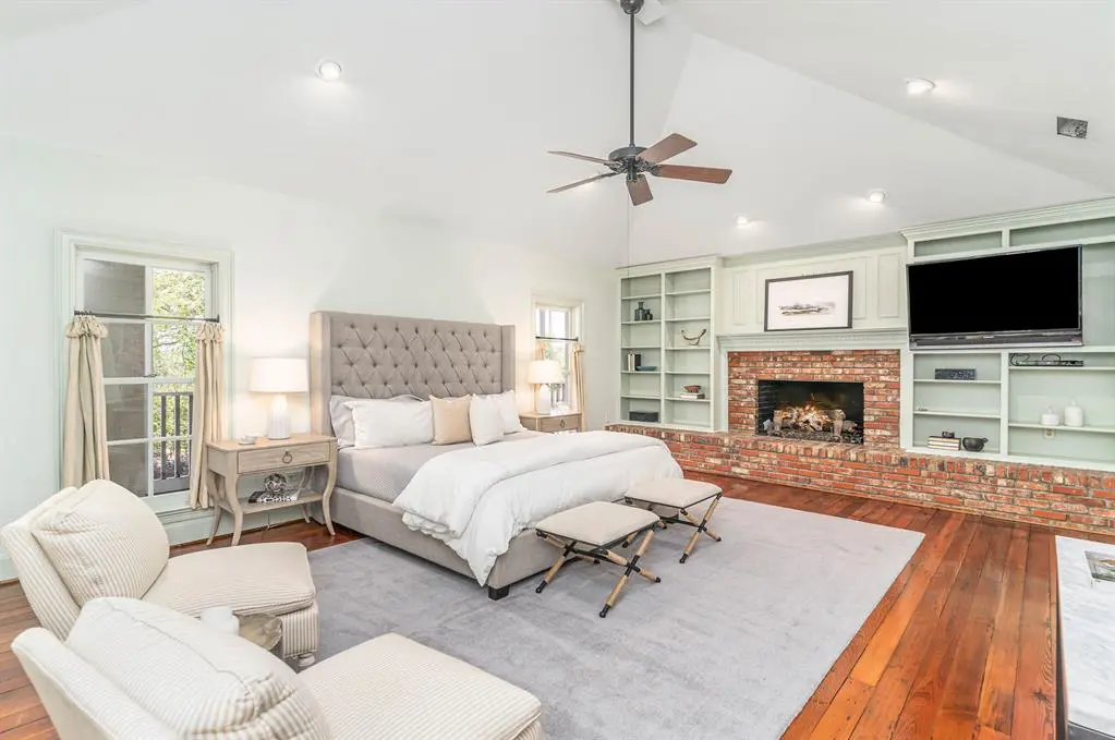 A brick-covered fireplace adds warmth to a master bathroom. 