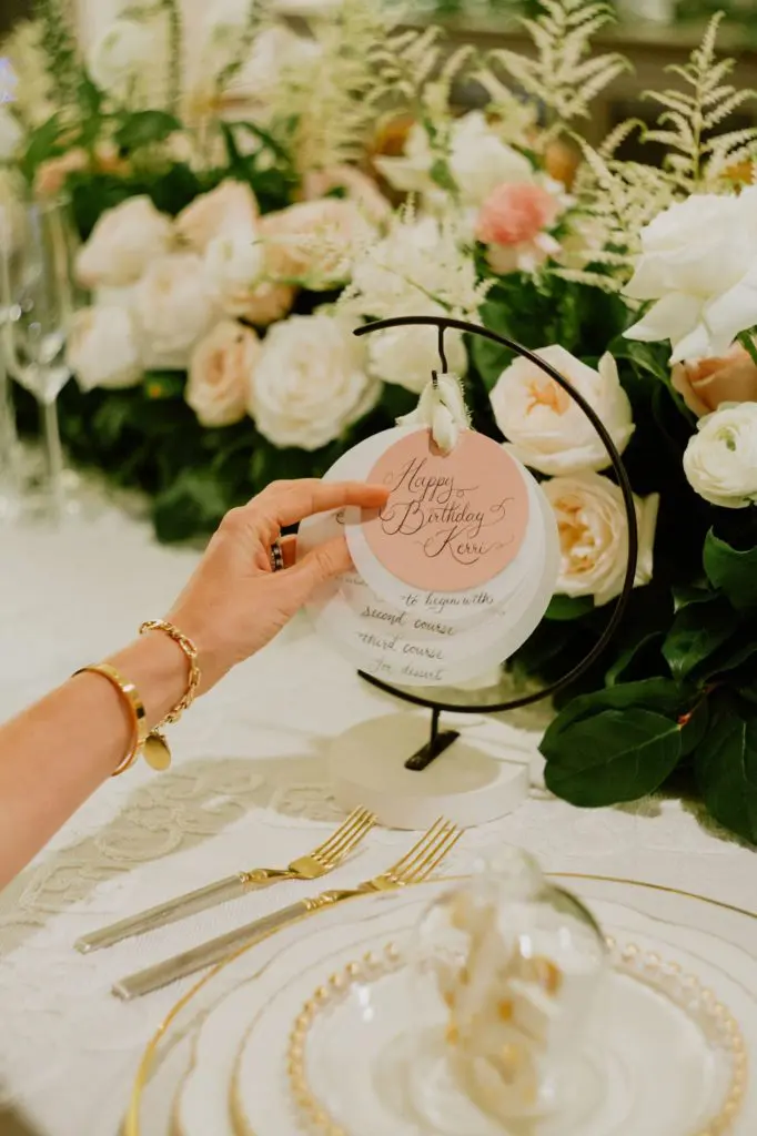 The 35th birthday is elegant with Casablanca cream table linen, clear glass with gold bead charger, and Marchesa Shades of Ivory. Brenden Williams Photography. Event design by Social Llama Events 