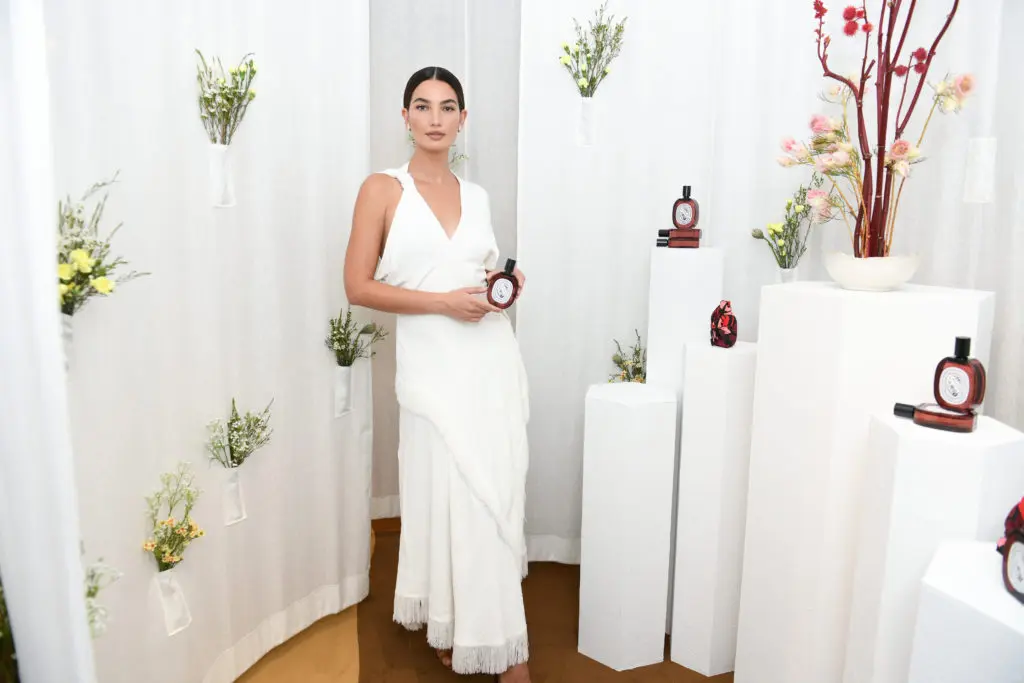 Model Lily Aldridge poses amid a floral area of the Diptyque pop-up show. (Photo courtesy of Diptyque)