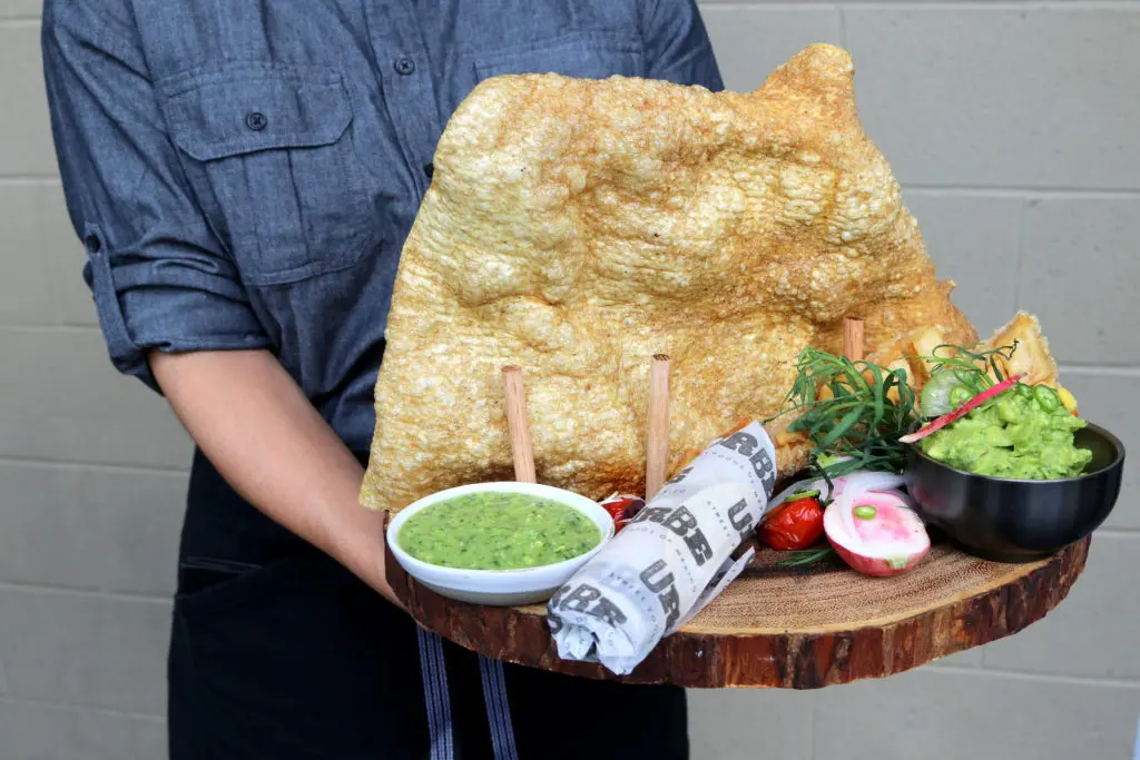 Chicharrones, a large fried pork rind is served as a starter with guacamole and salsa verde.  (Photo by Paula Murphy)